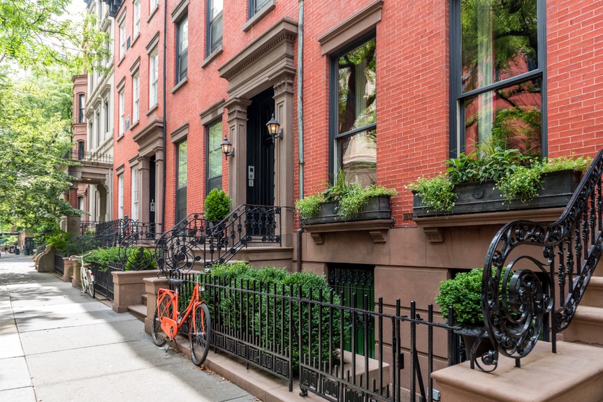 Brick apartments with sidewalk and orange bike